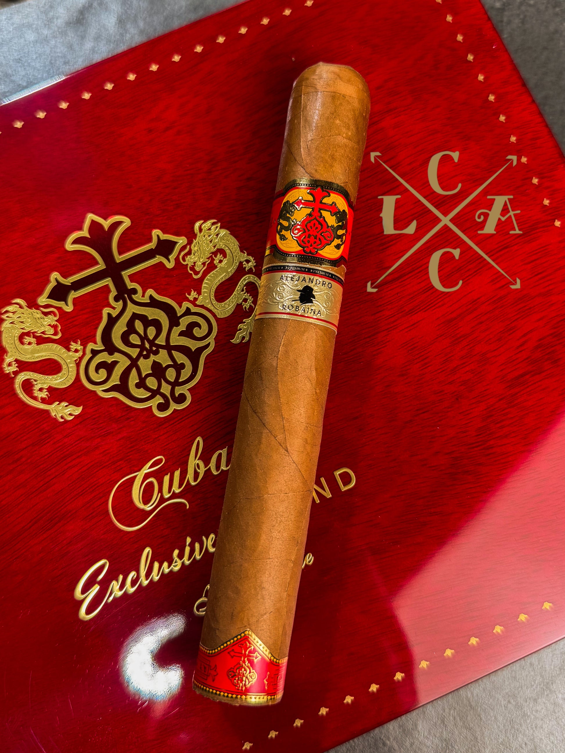 Cigar with a red band on a red box labeled 'Cuban Exclusive' with a logo.