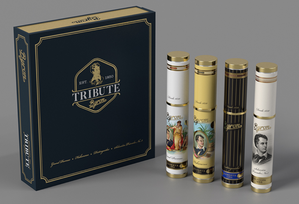 A Tribute cigars presentation set featuring a dark navy blue and gold presentation box alongside four individual cigar tubes in white, gold, and black designs with gold caps, on a neutral gray background.