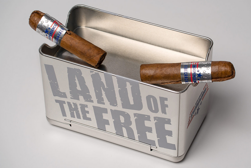 Cigar holder with two cigars and 'Land of the Free' text on a white background