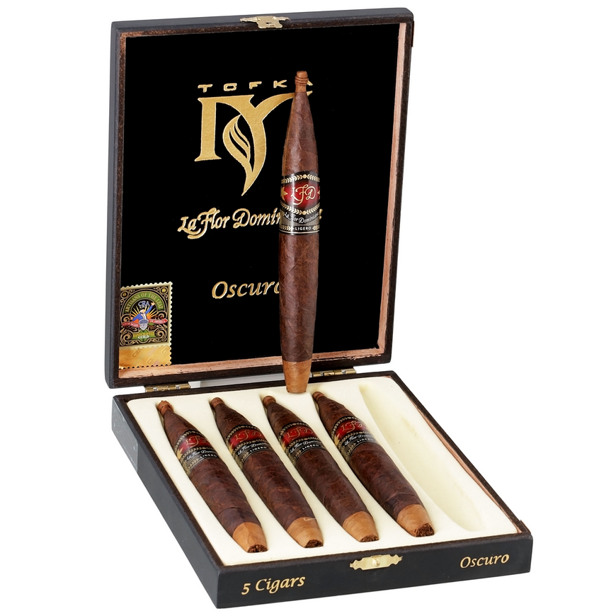 Open box of Le Flor Dominica cigars with a single cigar standing upright.