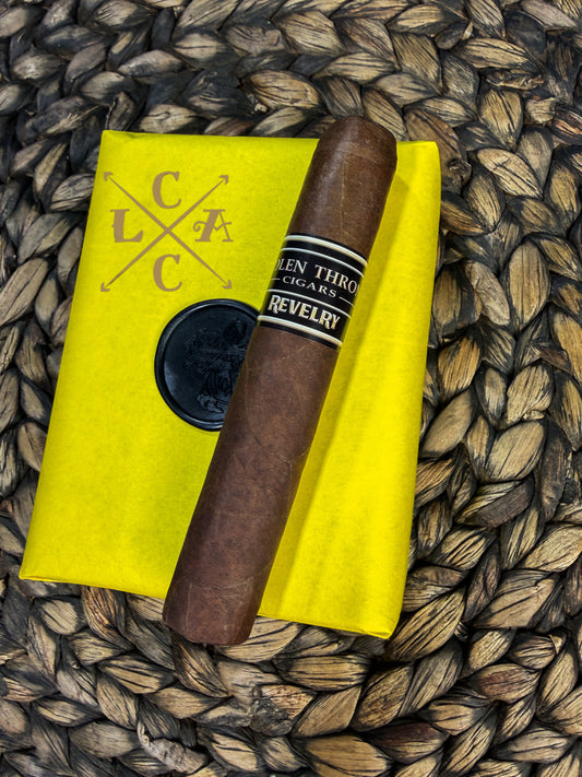 Cigar on a yellow linen with 'LCAC' branding on a woven surface