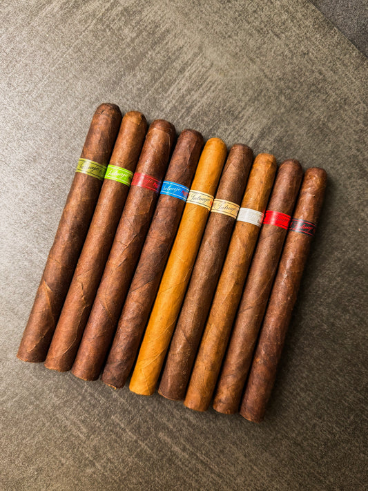 Assorted cigars with color-coded bands on a textured surface