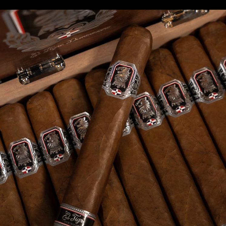 Close-up of cigars with decorative bands on a wooden humidor.