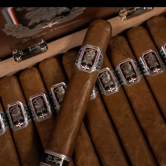 Close-up of cigars with decorative bands on a wooden humidor.